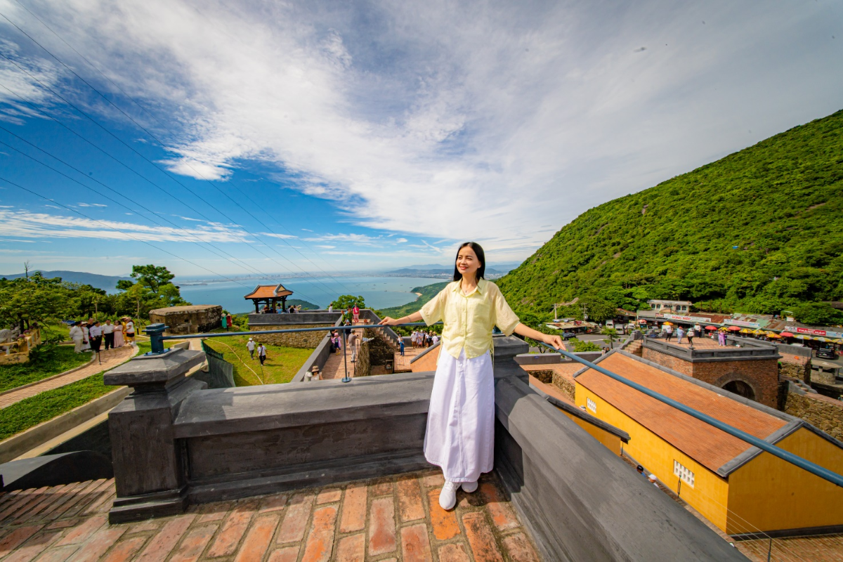 A tourist capturing a stunning view at Hai Van Pass